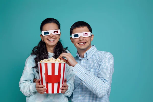 Couple en rouge-bleu 3d lunettes manger pop-corn à partir du seau — Photo