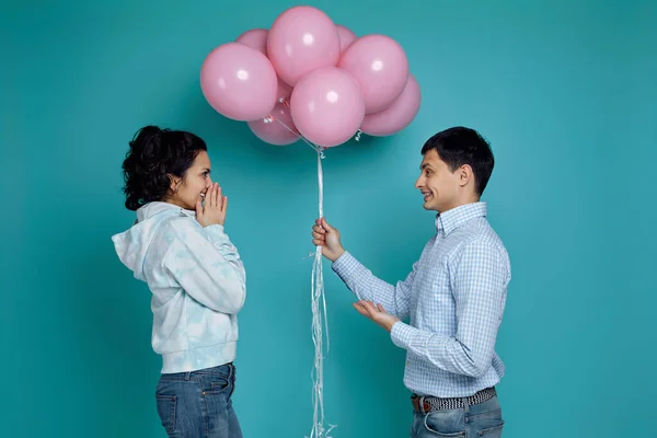 Hombre presentando globos de aire rosa a novia sobre fondo azul — Foto de Stock