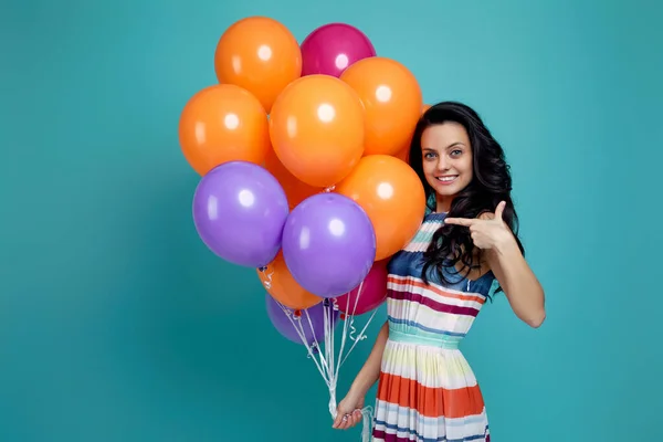 Menina no vestido segurando balões de ar coloridos brilhantes — Fotografia de Stock