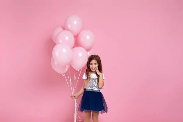 Kind meisje poseren met pastel roze lucht ballonnen — Stockfoto