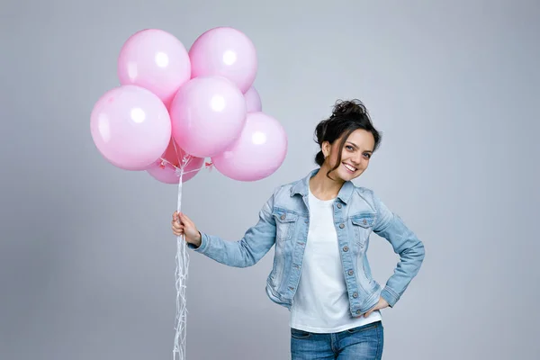 Chica en denim celebración de pastel rosa globos de aire — Foto de Stock