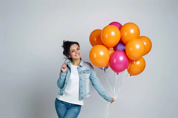 Parlak renkli hava balonlarıyla poz veren kot giyen kız. — Stok fotoğraf