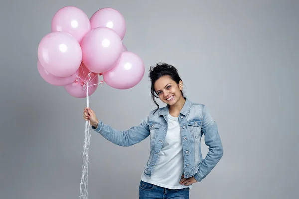 Chica en denim celebración de pastel rosa globos de aire — Foto de Stock