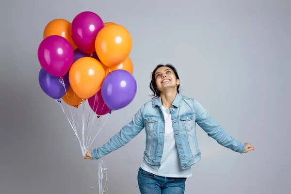 Parlak renkli hava balonlarıyla poz veren kot giyen kız. — Stok fotoğraf