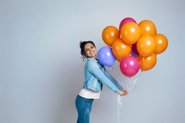 Chica en denim posando con brillantes globos de aire de colores — Foto de Stock