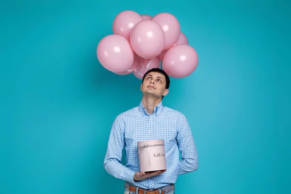 Hombre sosteniendo caja de regalo y pastel globos de aire rosa — Foto de Stock