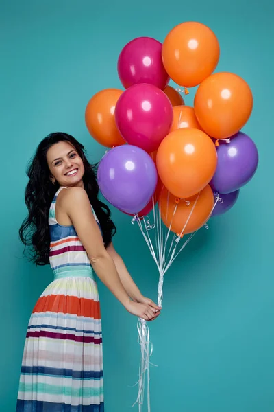 Chica en vestido celebración de brillantes globos de aire de colores — Foto de Stock