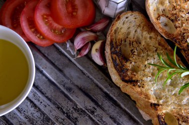 Kırsal metal tepside beyaz ekmek tostu ile domates dilimi peyniri ve sarımsak.