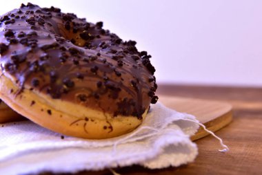 Çikolatalı çörekler. Tahta masaya koyu çikolata serpiştirilmiş.