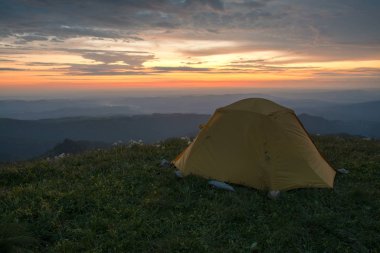 Çadır, şafak vakti dağda durur. Dağlarda.