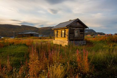 Teriberka 'da günbatımında eski ahşap bir ev. Rusya