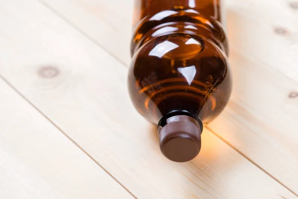 brown plastic bottle lying on the board