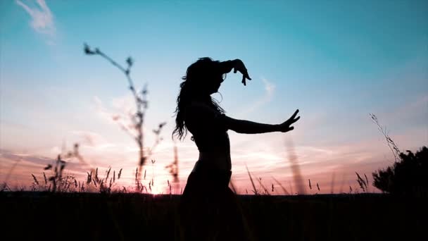 Σιλουέτα του λεπτό κορίτσι χορό κατά το ηλιοβασίλεμα. — Αρχείο Βίντεο