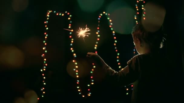 The child holds a sparkler — Stock Video