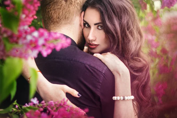 Gelin ve damat leylak ağacının yanında. Birbirine aşık çiftler bahar bahçesinde kucaklaşıyorlar. Boynunda narin bir kolye olan mor kolsuz bir kadın. Siyah takım elbiseli kızıl saçlı adam bir kızı öpüyor ve sarılıyor. Güzel parkta düğün..