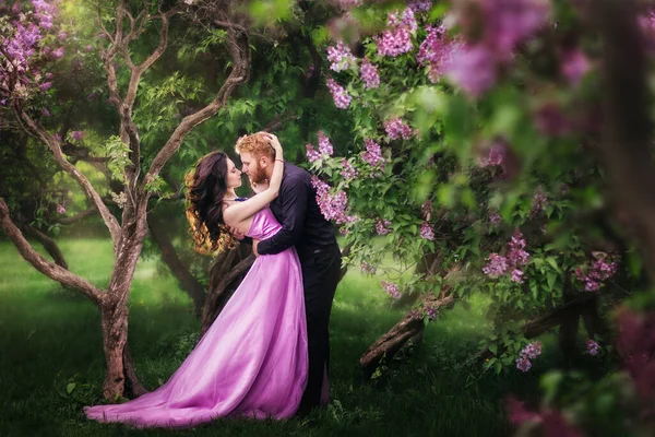 Gelin ve damat leylak ağacının yanında. Birbirine aşık çiftler bahar bahçesinde kucaklaşıyorlar. Boynunda narin bir kolye olan mor kolsuz bir kadın. Siyah takım elbiseli kızıl saçlı adam bir kızı öpüyor ve sarılıyor. Güzel parkta düğün..