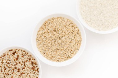 Farklı türde pişmemiş pirinç içeren kaseler: kahverengi, kırmızı, beyaz, glutinous. Asya 'nın en popüler sağlıklı yiyeceği.