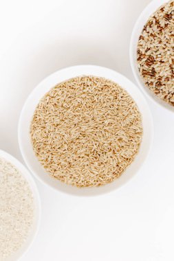 Farklı türde pişmemiş pirinç içeren kaseler: kahverengi, kırmızı, beyaz, glutinous. Asya 'nın en popüler sağlıklı yiyeceği.