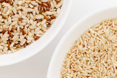 Farklı türde pişmemiş pirinç içeren kaseler: kahverengi, kırmızı, beyaz, glutinous. Asya 'nın en popüler sağlıklı yiyeceği.