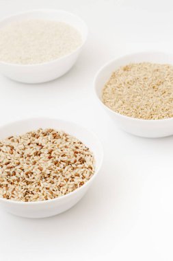 Farklı türde pişmemiş pirinç içeren kaseler: kahverengi, kırmızı, beyaz, glutinous. Asya 'nın en popüler sağlıklı yiyeceği.