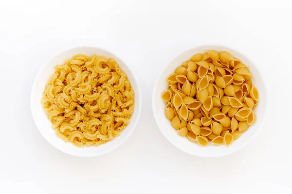 Twee Verschillende Soorten Ongekookte Pasta Witte Kommen Geïsoleerd — Stockfoto