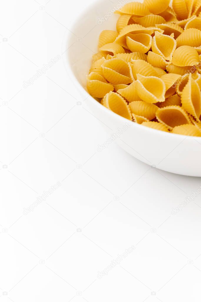 Delicious pasta or penne noodles, isolated on white background. Top view scene, healthy eating or healthy lifestyle. Penne pasta or macaroni in a white bowl, italian cuisine.