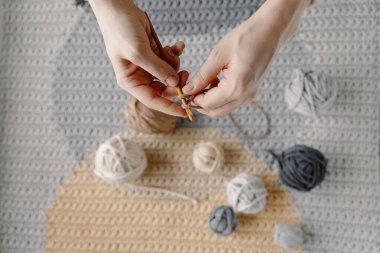 Kız güzel beyaz bir halı ya da pamuk ipliği örüyor. Örgü iğneleriyle kadın elleri. Rahat ev hobisi