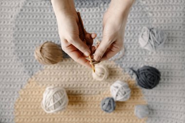 Kız güzel beyaz bir halı ya da pamuk ipliği örüyor. Örgü iğneleriyle kadın elleri. Rahat ev hobisi