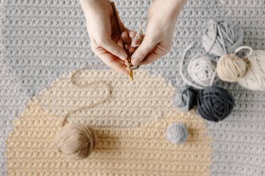 Kız güzel beyaz bir halı ya da pamuk ipliği örüyor. Örgü iğneleriyle kadın elleri. Rahat ev hobisi