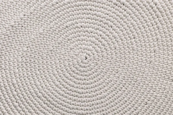Knitted white rug texture. Antique handmade round carpet. Home hobby. Background