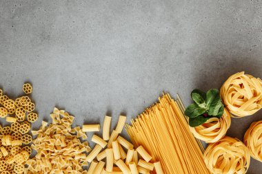 Beton arka planda İtalyan Makarnası malzemeleri. Metin için boş alanı olan düz uzandı.