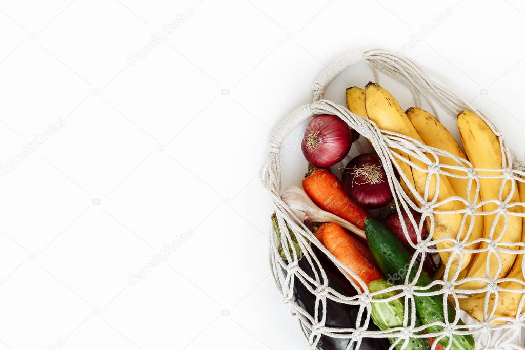 Shopping bag with vegetables and fruits on white background, isolated, top view with copy space