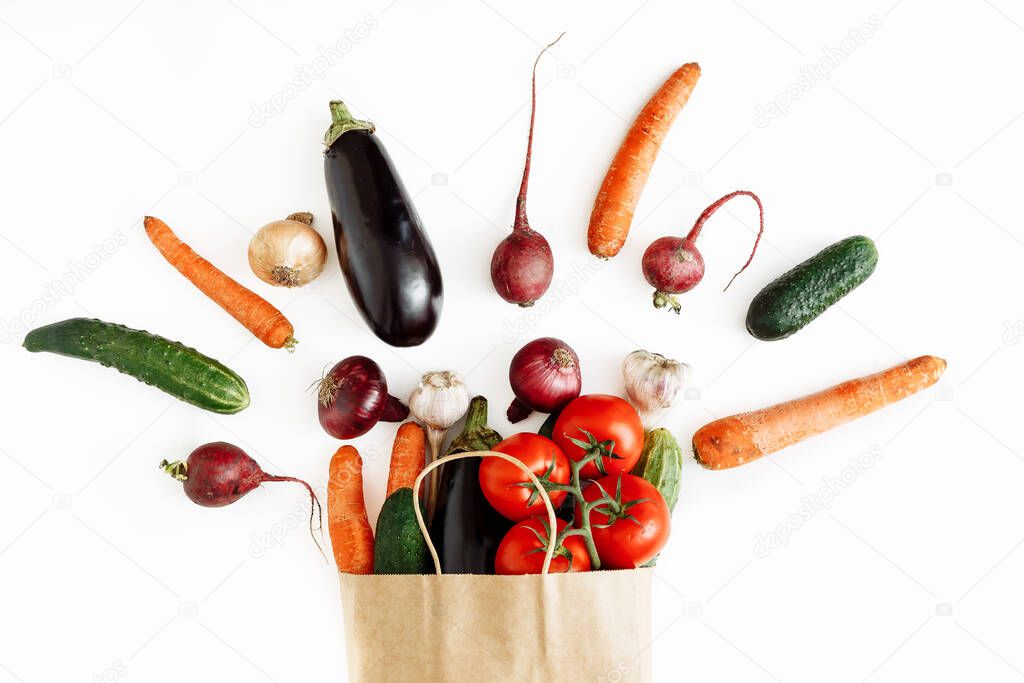 Fresh vegetables in paper bag on white background, isolated.