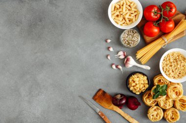 Ahşap masa üzerinde makarna pişirmek için malzemeli spagetti ve fettuccine ile ahşap mutfak tahtası boş, üst manzara. Kırsal tarzda. Boş alan ile düz uzandı