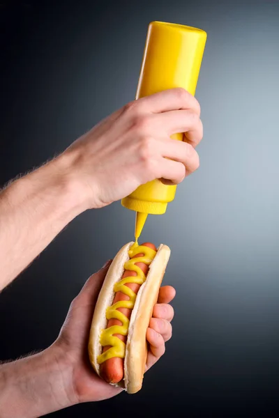 Senf auf Hot Dog drücken — Stockfoto