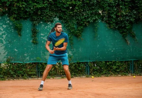 Homme concentré jouant au tennis, tenant une raquette et regardant le bal — Photo