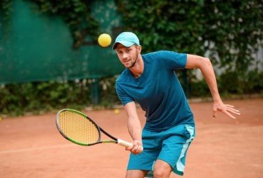 Tenis antrenmanından zevk alan bir adam