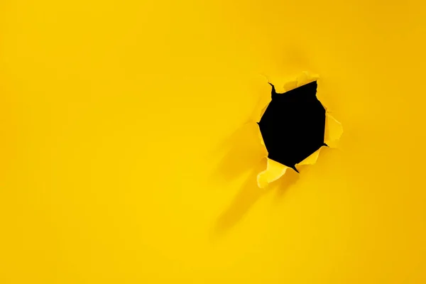 Agujero roto en fondo de papel amarillo . —  Fotos de Stock