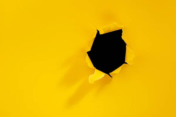 Agujero roto en fondo de papel amarillo . — Foto de Stock