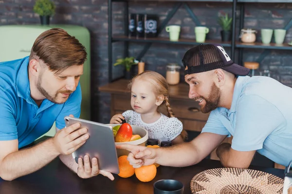 Fathers and their daughter cooking a salad following to instructions — Stock Photo, Image