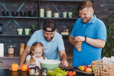 Babası küçük kızına salata pişirmeyi öğretiyor.