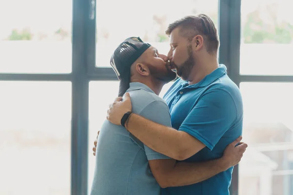 Гей-чоловіки цілуються перед вікнами — стокове фото