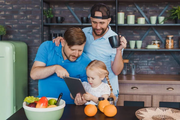 Lgbt Eltern und ihre Tochter mit einem Tablet-Computer in der Küche — Stockfoto
