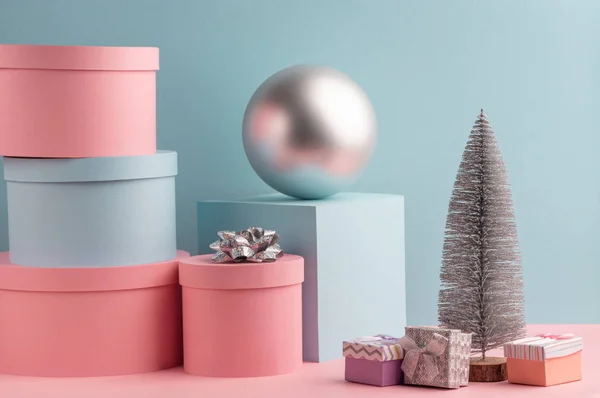 Елка, мяч, круглые и квадратные подарочные коробки на розовом и бирюзовом фоне — стоковое фото