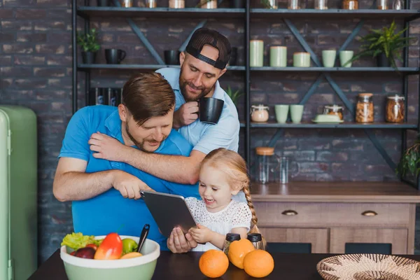 Vorsichtige schwule Eltern und ihre Tochter beim guten Frühstück in der Küche — Stockfoto