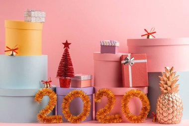 Hediye kutuları, köknar ağacı ve pembe arka planda 2020 numara.