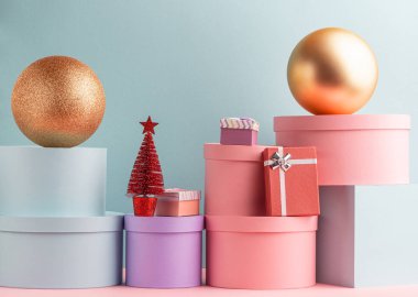 Türkuaz arka planda çeşitli hediye kutuları, toplar ve Noel ağacı yığını