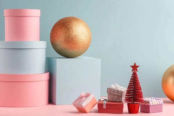 Teal és rózsaszín ajándékdobozok, piros karácsonyfa és arany labdák — Stock Fotó