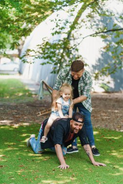 Eşcinsel çift arka bahçede çocuklarıyla oynuyor.