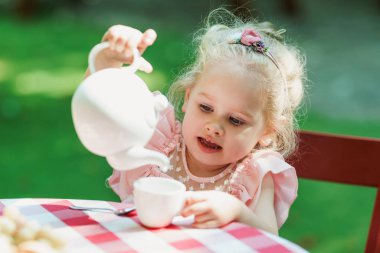 Küçük fincana çay dolduran kız